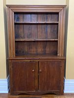 Full frontal view of antique hutch showing two shelves and cabinet