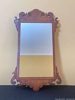 Front view of antique Georgian mahogany fretwork wall mirror showing detailed scroll decorations along the edges and clear reflective glass.