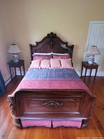 Assembled bed frame with linens and pillows against wall