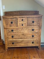 Front view of tiger maple dresser with visible wood grain and seven drawers.