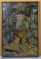 Frontal view of the framed abstract mixed-media collage artwork depicting a stylized human face composed of collaged paper fragments in subdued colors.