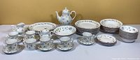 Full set of Johnson Brothers dishware arranged on table showing plates, bowls, tea cups and pot