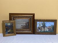 Three framed paintings on board arranged side by side showing overall lot contents and scale