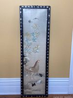 Full view of the framed silk screen embroidery with bird and floral design.