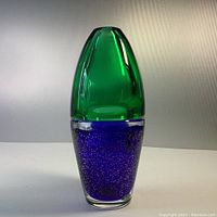 Photo of MCM Bohemian heavy glass vase showing cobalt blue base with silver inclusions and green glass top from front angle.