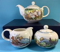 Photo of full set: teapot, creamer, and sugar bowl with hand-painted Winnie the Pooh story scenes.