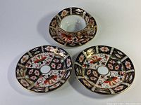 Image showing one Royal Crown Derby Imari pattern cup with matching saucer, second and third saucer placed below