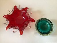 Top view showing star-shaped red bowl with clear bubble protrusions and round teal bowl with internal bubbles.