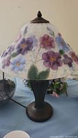 Artisan glass shade table lamp with floral painted shade and dark metal base