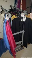 Clothing rack with colorful satin-like tops and black jackets hung on hangers.