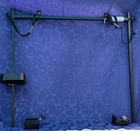 Full view of black adjustable aluminum dog grooming bar with clamps and leash noose