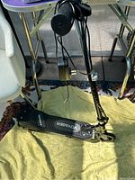 Front and side profile of Voyager black electric kids scooter showing deck, wheels, and charger cable.