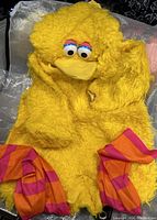 Yellow Big Bird costume with hood and striped legs laid flat