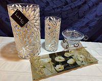 Photo showing the pair of decorated glass vases, crystal bowl on metal stand, and floral glass platter on a white cloth.