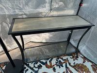 Full front view of the console table showing the metal frame, light wood top, and glass shelf