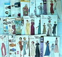 Photo showing a large assortment of vintage sewing pattern envelopes from brands Vogue, McCalls, Simplicity, Butterick, See & Sew, and Very Easy Vogue. Various dress and pant designs displayed.
