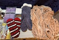 Photo showing fuzzy soft robe, knitted socks, body wrap, and packaged items including face masks.