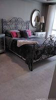 Full view of queen bed frame assembled in room with bedding and accent cushions