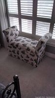 Photo of full fabric covered bench with black scenic toile print near window, showing armrests and general shape