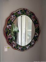Full front view of round mirror with floral stained glass frame