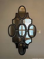 Front view of nine-panel decorative wall mirror in black frame, showing overall design and arrangement.