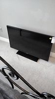 Samsung 40 inch flat-screen TV positioned on the floor with black bezel and screen off.