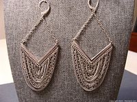 Pair of sterling silver chain earrings hanging on display stand, showing full design and shape