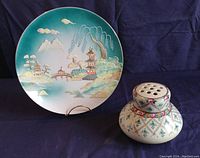 View of the two porcelain pieces side by side: moriage scenic wall plaque and flower frog vase