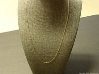 Full view of the 9K gold chain necklace displayed on a necklace bust stand, showing its fine chain links and length.