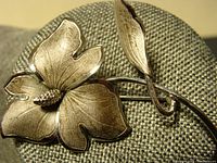 Front view of sterling silver floral brooch showing textured petals and center pistil detail