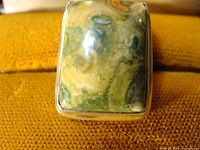 Close-up of the rectangular green multi-tone stone in sterling silver ring, showing natural stone patterns and polished finish.