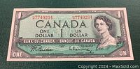 Front side of the 1954 Bank of Canada one dollar bill showing Queen Elizabeth II portrait, serial number, and bilingual text.