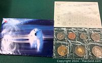 Sealed coin set with seven Canadian coins and polar bear packaging with information sheet.