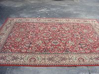 Full view of the rug laid flat, showing overall red floral pattern and beige border.