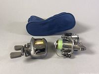 Daiwa Procaster-X 1531 and Biomaster 2000 reels side by side with blue carrying case