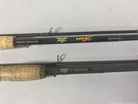 Close-up of the cork handles and Fenwick branding on two fishing rods (HMX and Technical).