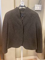 Full view of brown Giorgio Armani wool/cashmere jacket on hanger, collarless, no visible buttons.