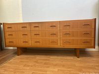 Front view of dresser showing nine drawers and integrated wood pulls