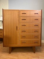 Front view of teak veneer tallboy chest cabinet showing six drawers and left-side cabinet