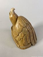 Front angled view of the carved eagle sculpture showing detailed feather work and elevated head.