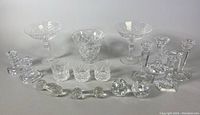 Full group showing all crystal items including compote bowls, whiskey glasses, candleholders, and knife rests.