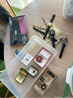 Overview photo of the entire lot showing watches, costume jewelry, brooches, rings in boxes and loose pieces on a table.