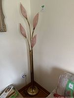 Full view of the floor lamp showing five curved brass-tone stems and round base