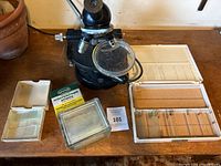 Overview of microscope with slides and slide boxes arranged on wooden surface