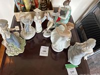 Full view of all 7 porcelain figurines grouped on a table showing various poses and colors
