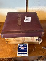 Photo of large burgundy Hungary stamp album with visible wear.