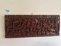 Full front view of the wood carved bas relief wall art showing the entire panel with detailed village scene