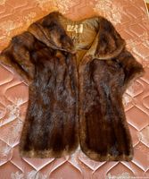 Full view of brown fur stole laid flat showing its size and shape.
