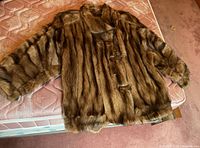 Full front view of brown mink fur coat laid flat