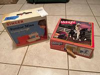 Original box of the Singer Junior Miss sewing machine and an unrelated Midnight toy horse box shown together.